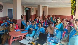 Female Community Health Volunteers (FCHVs) in Nepal raising their hands to show confidence in using the mobile app.