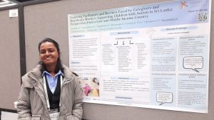 Shehara Mayadunne in front of one of the NAMASTE INSAR posters.